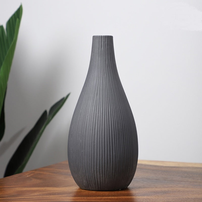 Vaso decorativo grigio scuro con superficie rigata e forma a goccia