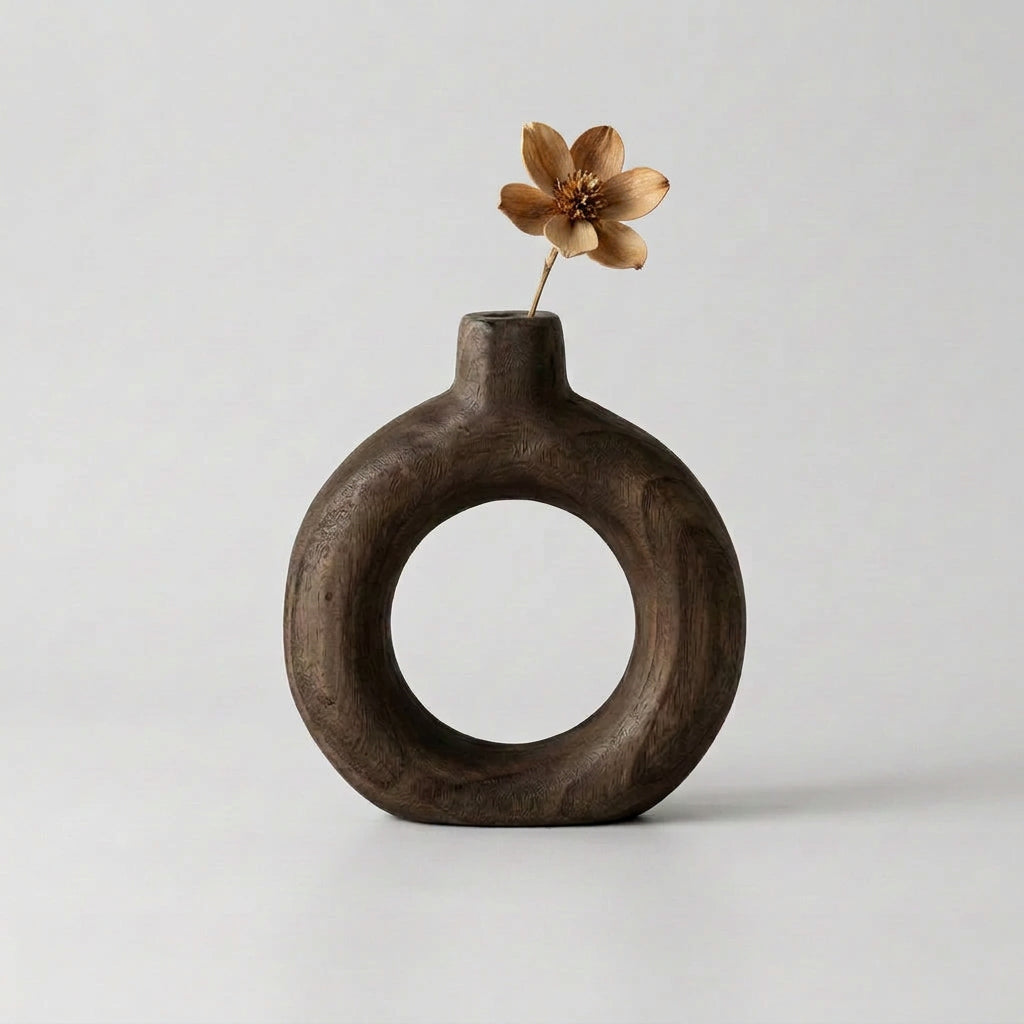 Vaso in legno scuro a forma circolare con piccolo fiore secco decorativo